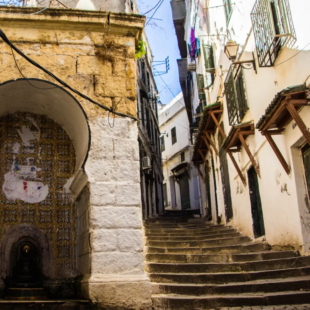 Narrow, sunlit alley with stairs.
